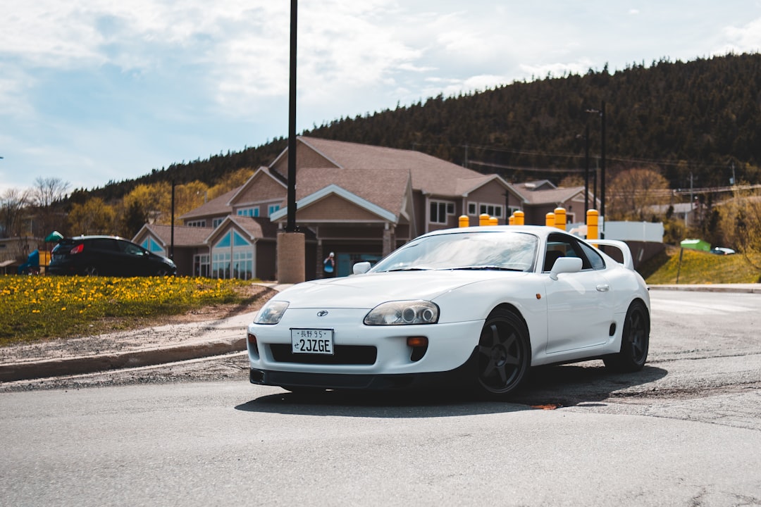 white bmw coupe parked on gray asphalt road during daytime