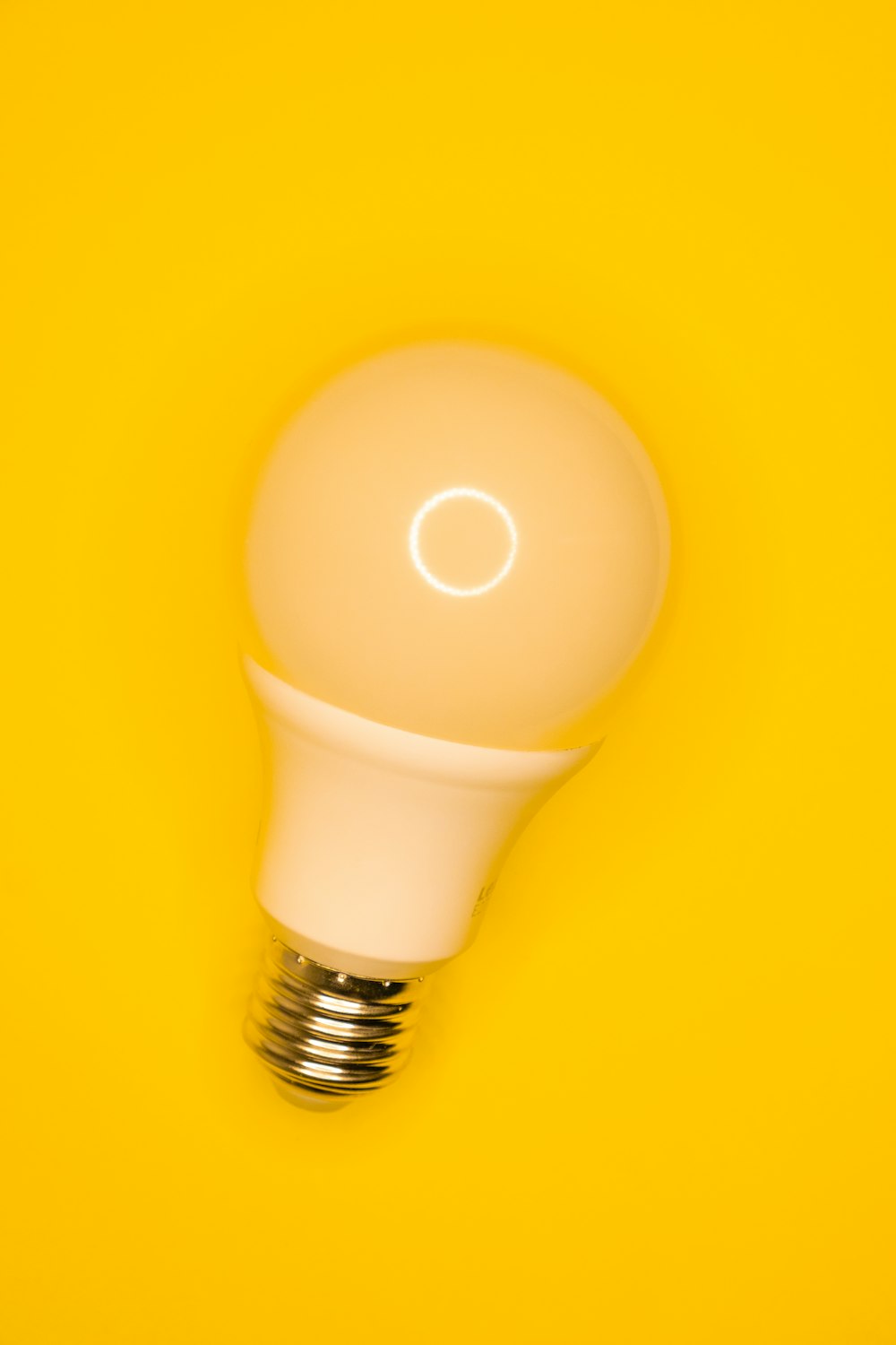 Ampoule blanche sur surface jaune