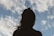 silhouette of woman under blue sky and white clouds during daytime