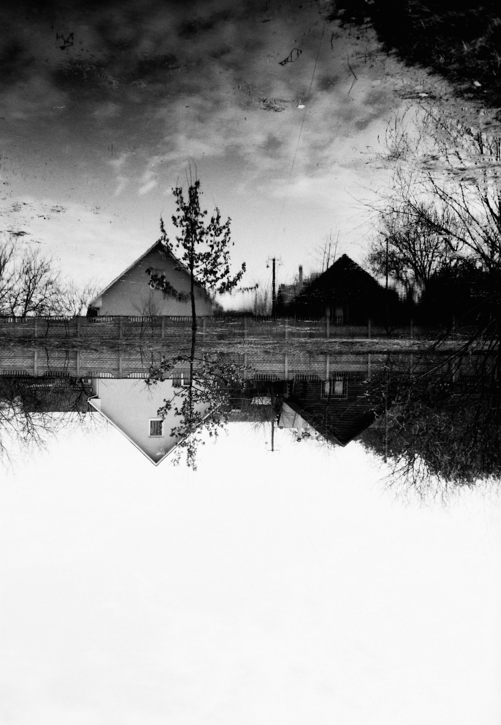 grayscale photo of house near lake
