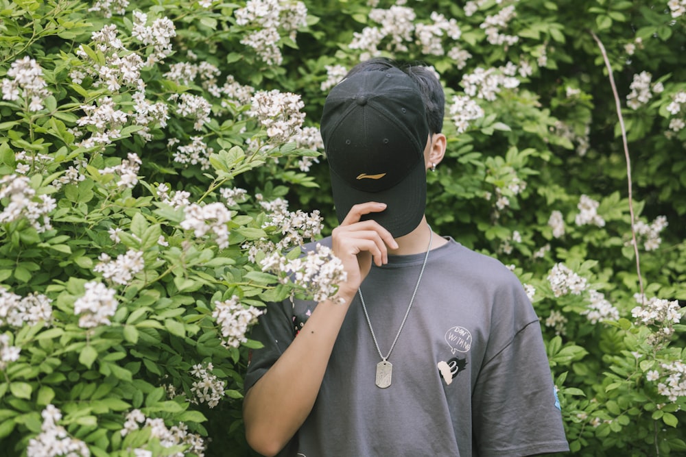 man in black crew neck t-shirt covering face with face with face mask