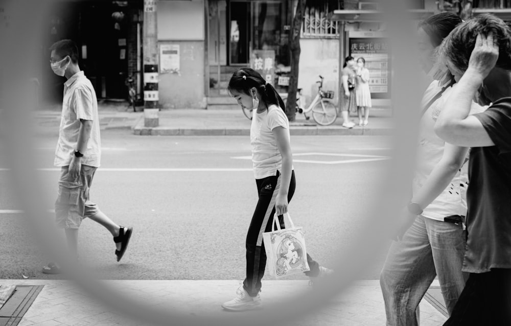 woman in white long sleeve shirt and black pants walking on street