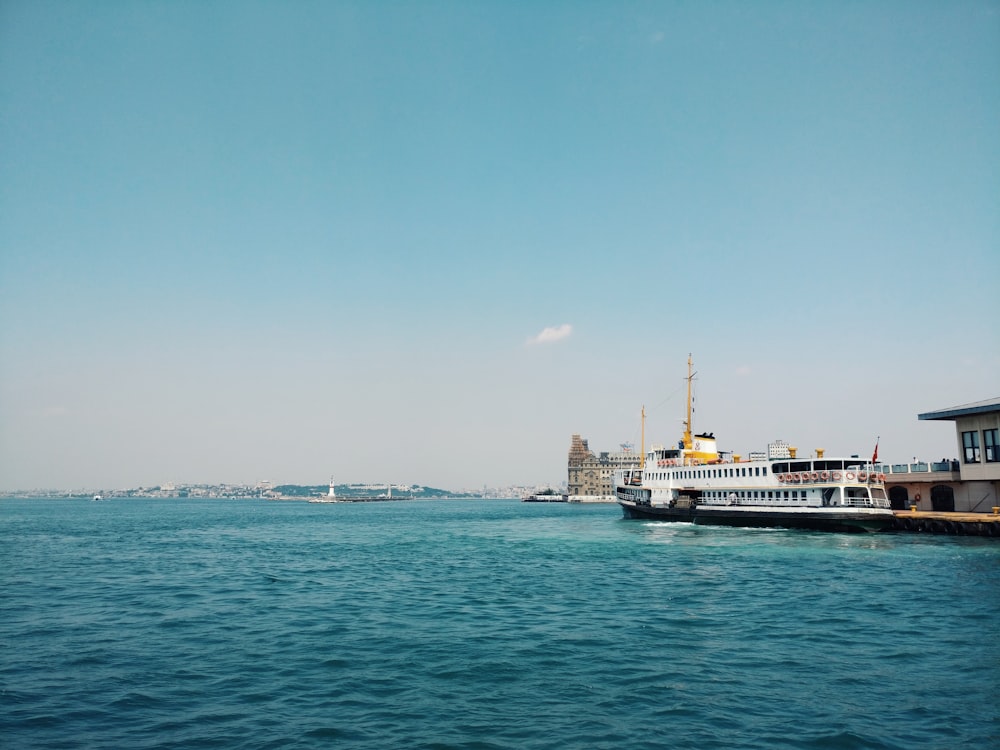 navio branco e preto no mar sob o céu azul durante o dia