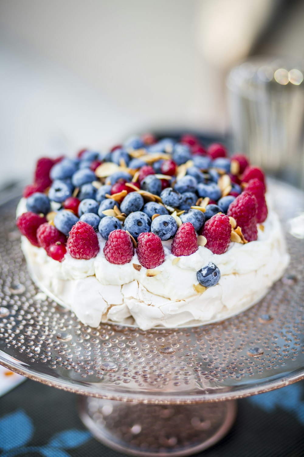 white icing covered cake with strawberry and blueberry on top