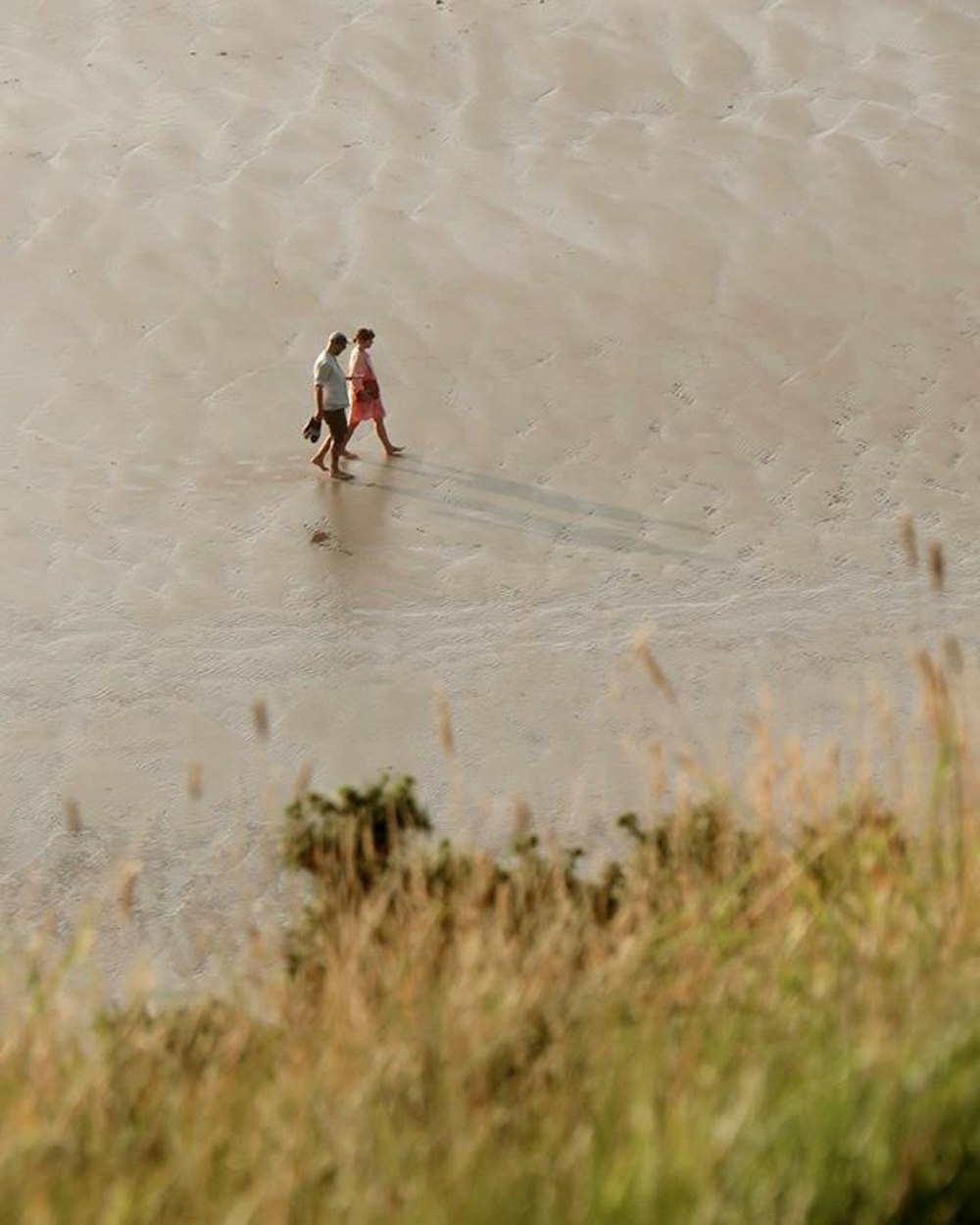 2 men playing ice hockey on white sand during daytime