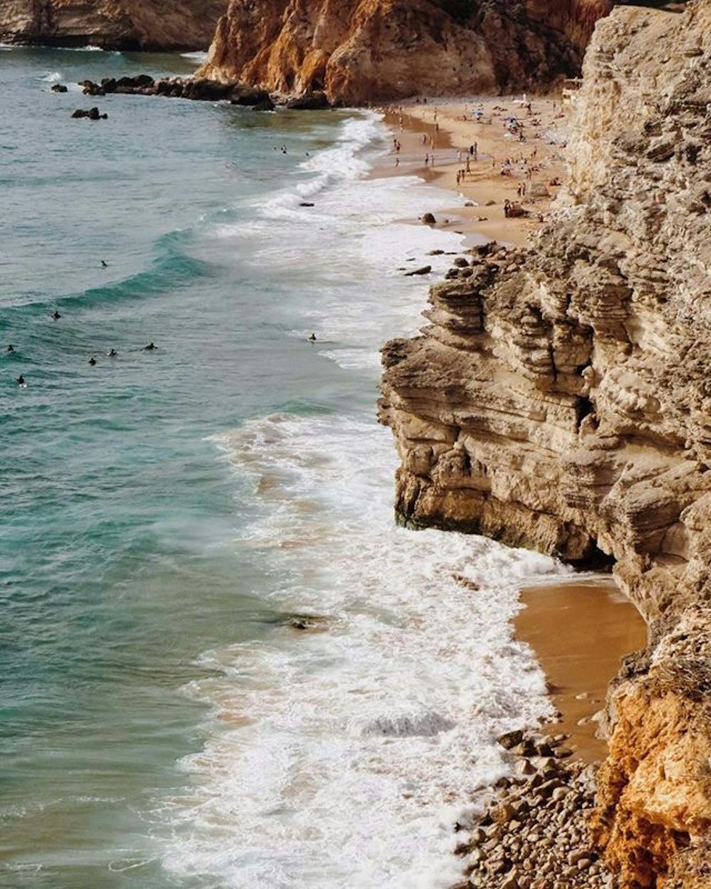 Montaña rocosa marrón junto al cuerpo de agua durante el día