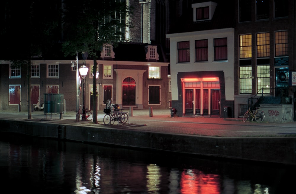 red and white concrete building near body of water during night time