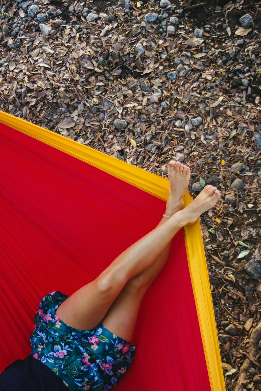 donna in vestito rosso sdraiata sull'amaca gialla e rossa