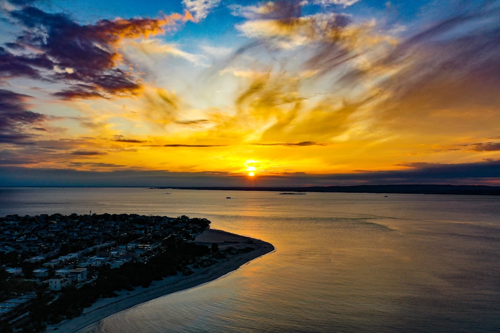 body of water under cloudy sky during sunset