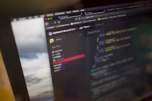 A computer screen displays a code editor with various files in a directory. The code being edited is written in JavaScript, identifiable by the .js file extension. There are highlighted lines in different colors to distinguish syntax elements. The left pane lists files such as 'assets', '.env', and 'index.js'. A web browser is visible at the top of the screen with multiple open tabs.