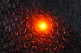 The image features a close-up view of bubble wrap illuminated from behind by a glowing orange light, creating a contrast with the transparent plastic material.