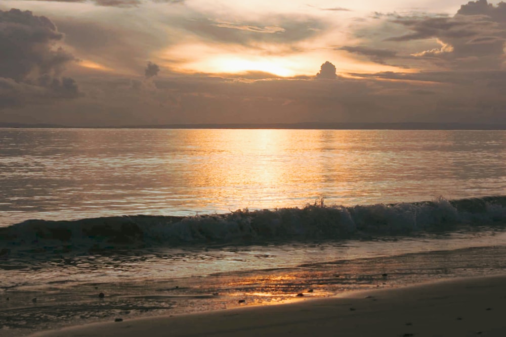 Onde dell'oceano che si infrangono sulla riva durante il tramonto