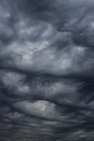Dark, swirling storm clouds fill the sky, creating an ominous and dramatic atmosphere. The cloud formations are dense and layered, suggesting turbulent weather.