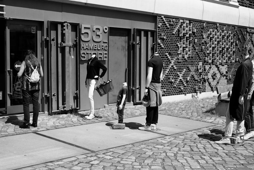 grayscale photo of man and woman walking on sidewalk