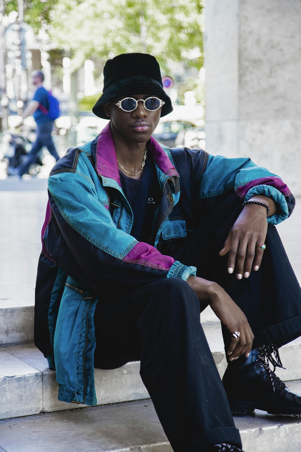 Mujer con chaqueta azul y pantalones negros con gafas de sol negras