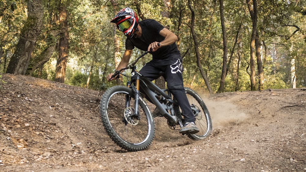 Mann im schwarzen Hemd fährt auf schwarzem Mountainbike