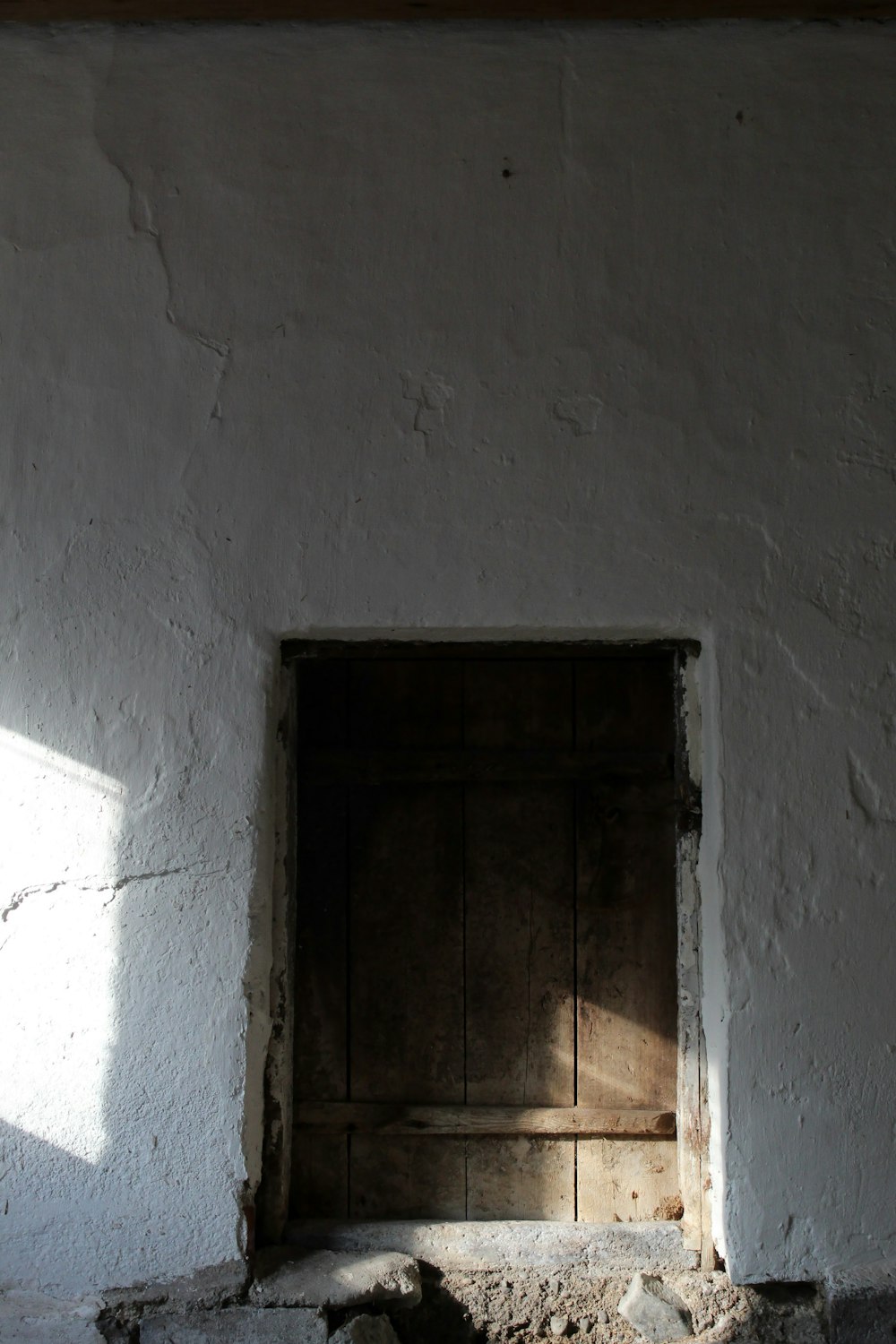 brown wooden door on white concrete wall