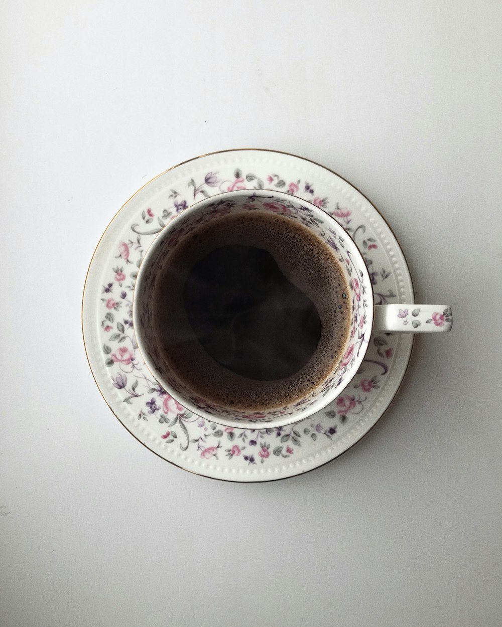 茶色の液体と白とピンクの花柄セラミックマグカップ