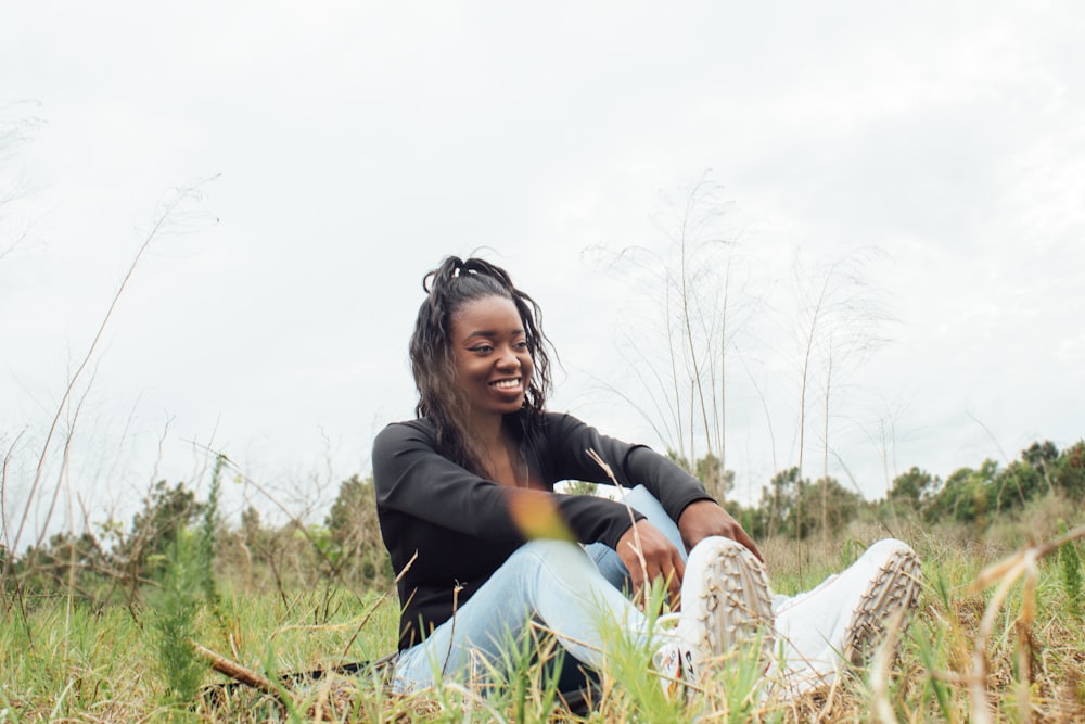 a woman sitting in a field of tall grass