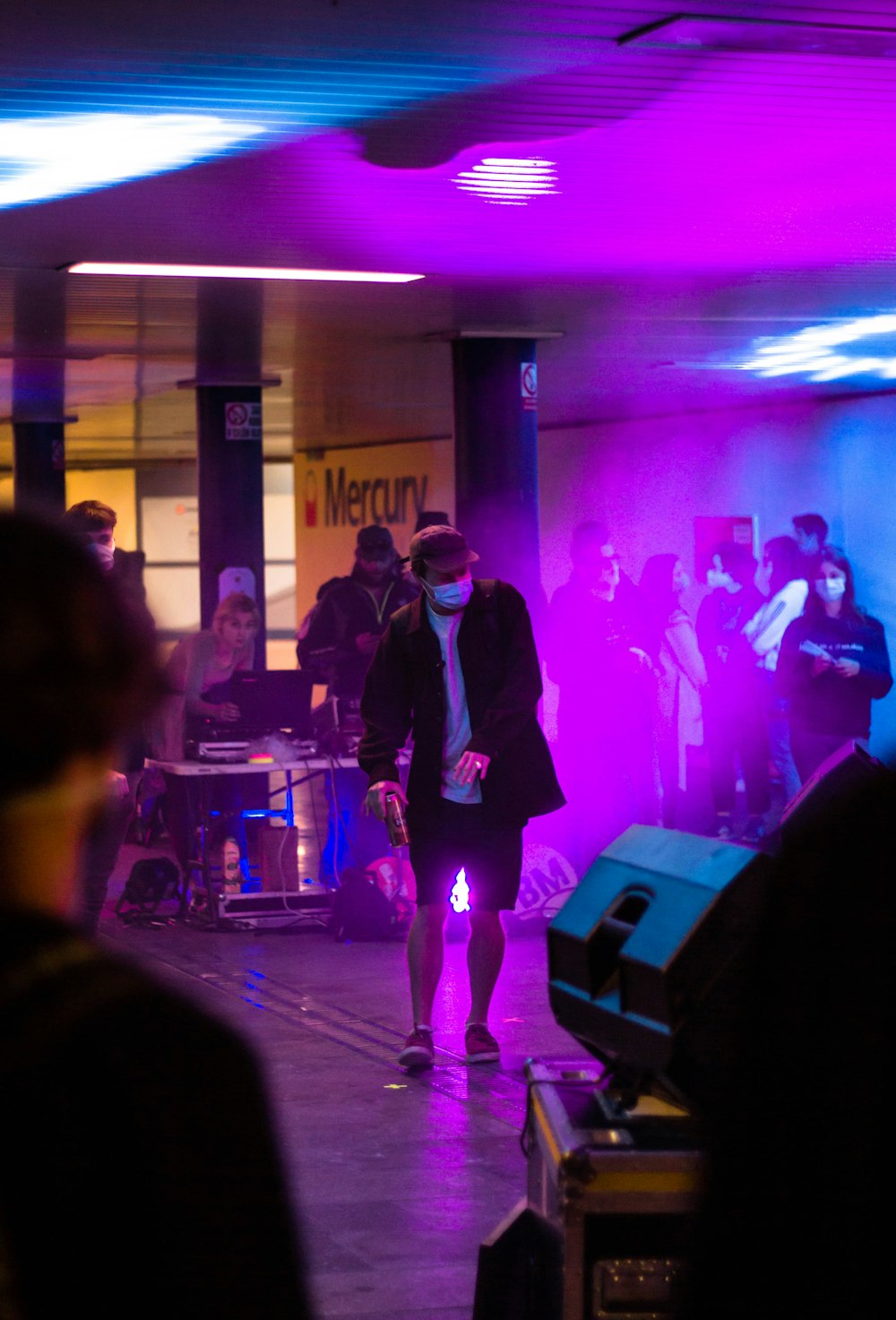 man in black suit standing on stage