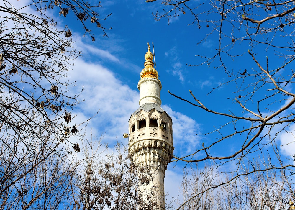 white concrete tower under blue sky and white clouds during daytime