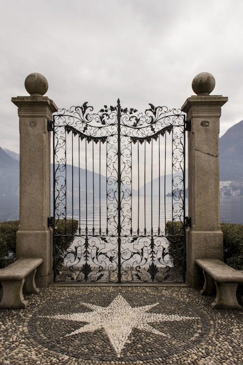 black metal gate near blue sea under blue sky during daytime