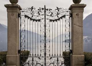 black metal gate near blue sea under blue sky during daytime