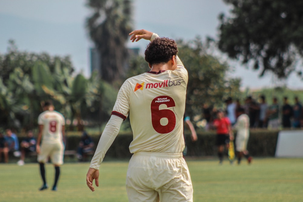 man in white and red nike soccer jersey shirt and beige pants