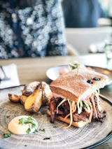 Happy customer enjoying a kabab sandwich in a cozy, bright setting.