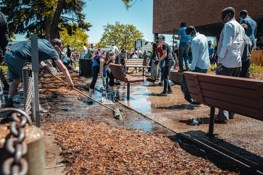 people sitting on brown wooden bench during daytime