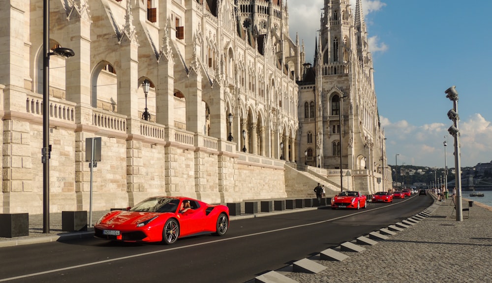 Roter Ferrari 458 Italia tagsüber in der Nähe eines weißen Betongebäudes geparkt