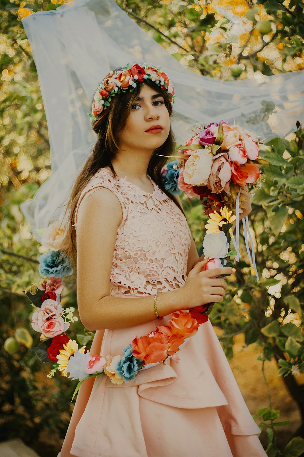 woman in white floral dress holding bouquet of flowers