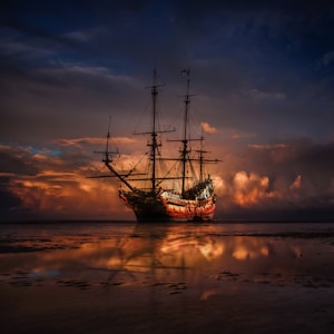 brown ship on sea during sunset