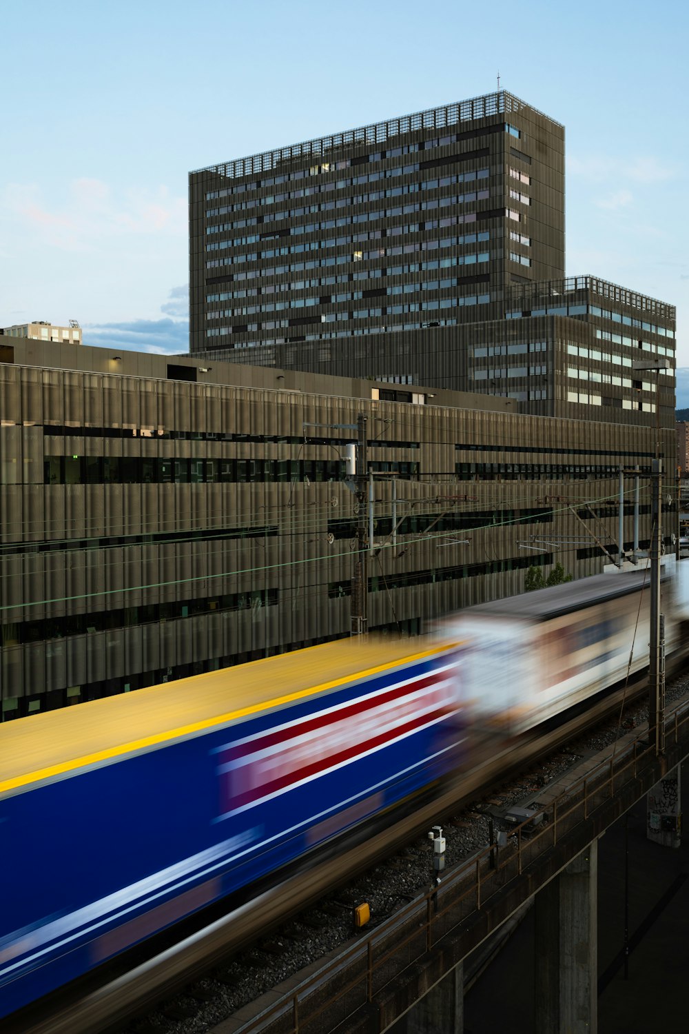 white and black train on rail near city buildings during daytime