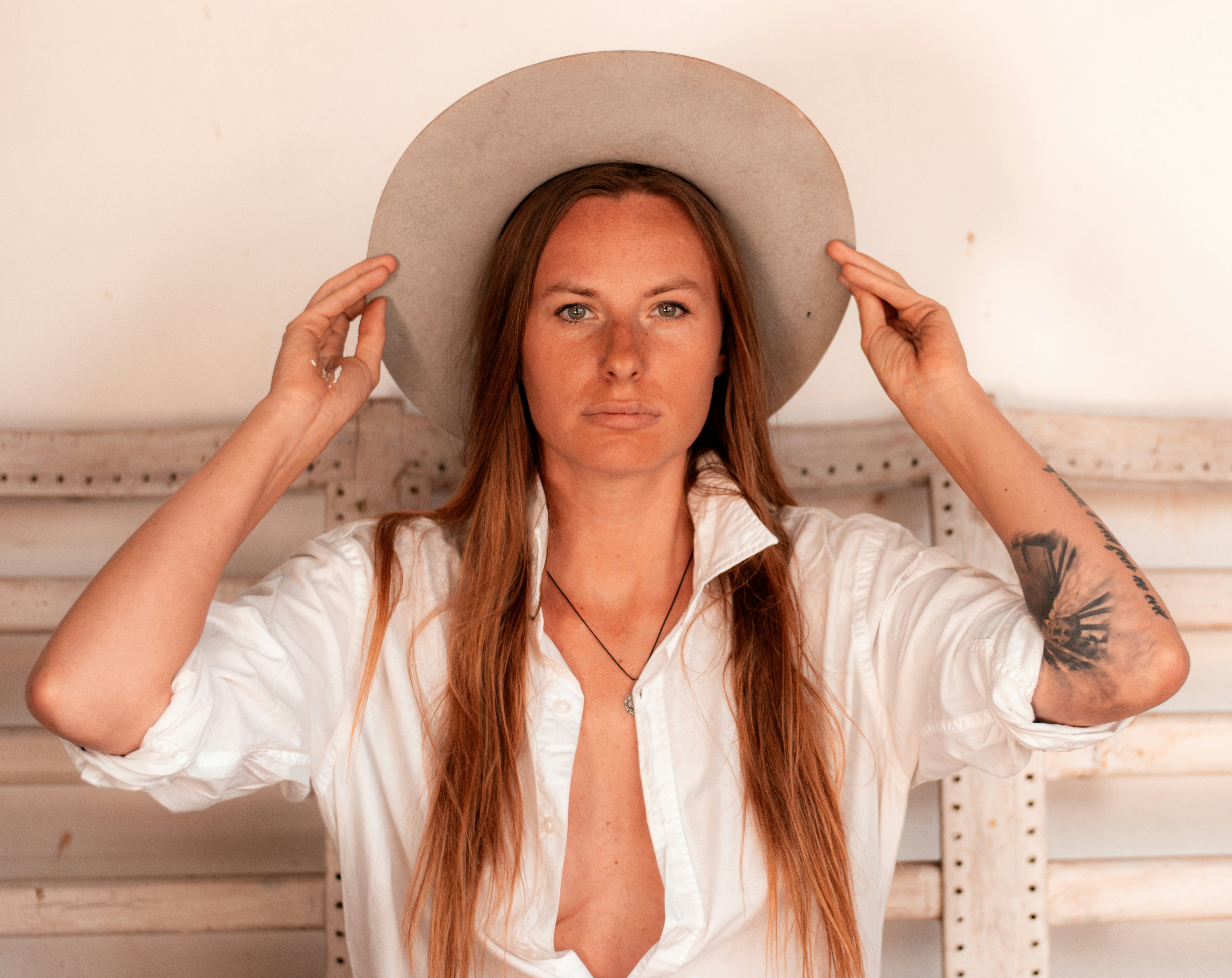 donna in camicia bianca che indossa cappello marrone