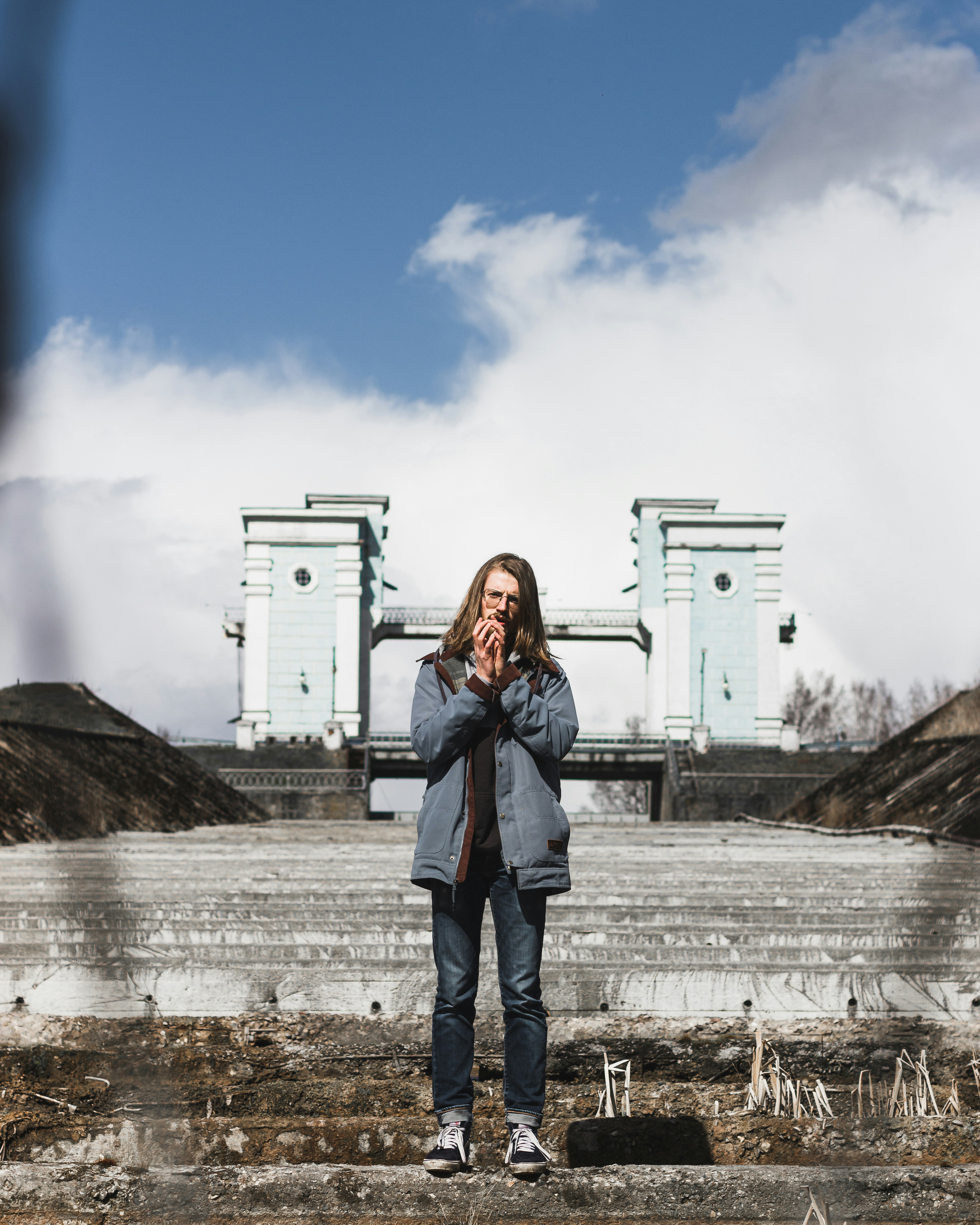 Mujer con chaqueta de mezclilla azul de pie cerca de un edificio blanco