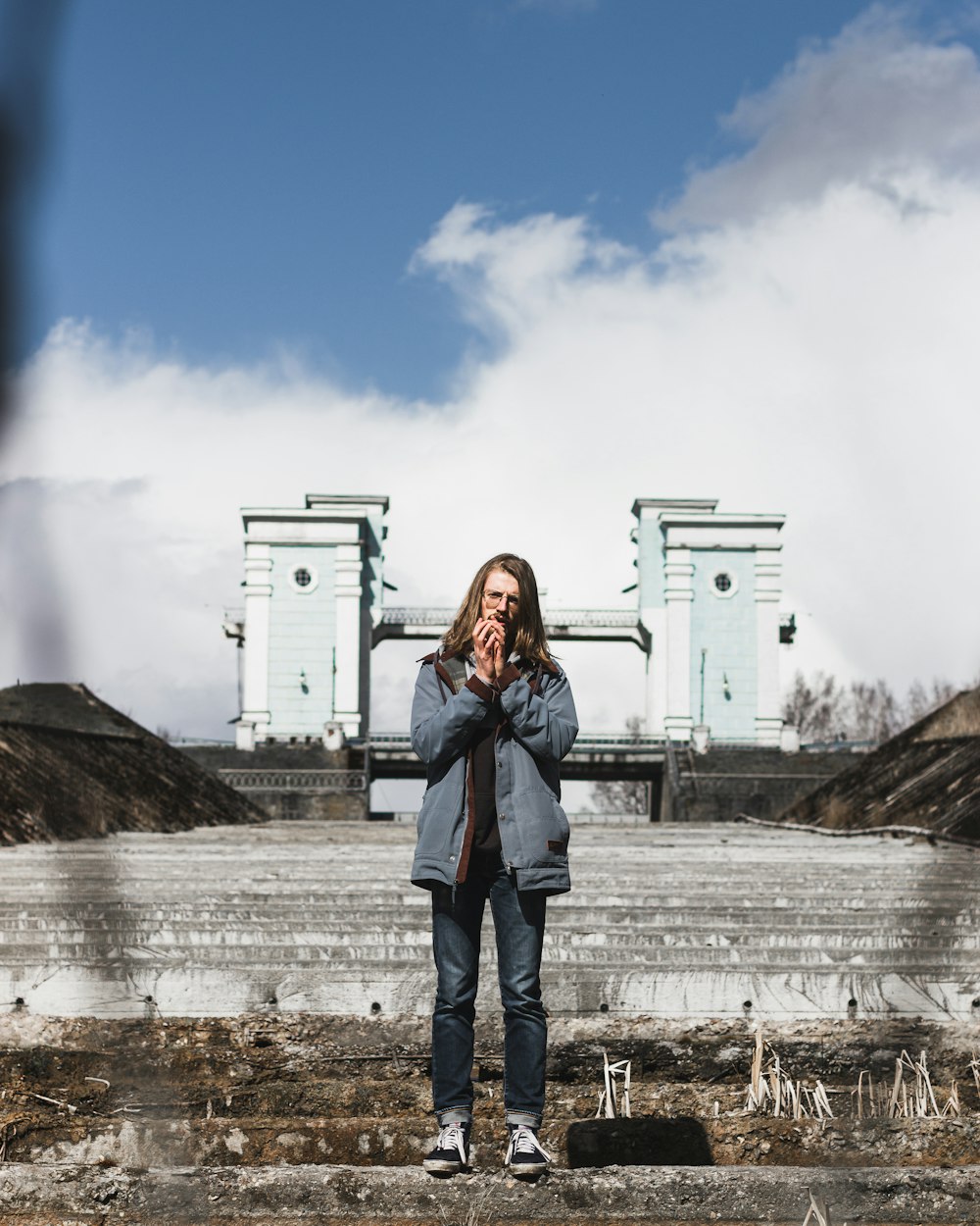 woman in blue denim jacket standing near white building