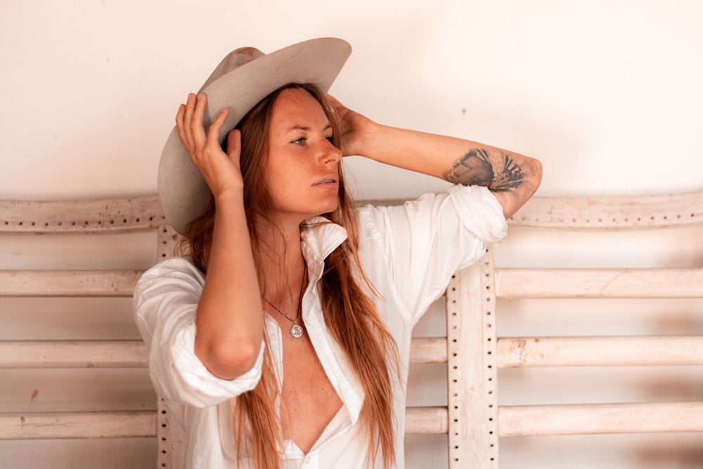 woman in white long sleeve shirt wearing brown hat