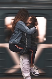 Woman kissing man in denim jacket and white pants, symbolizing connection and male HIV prevention.