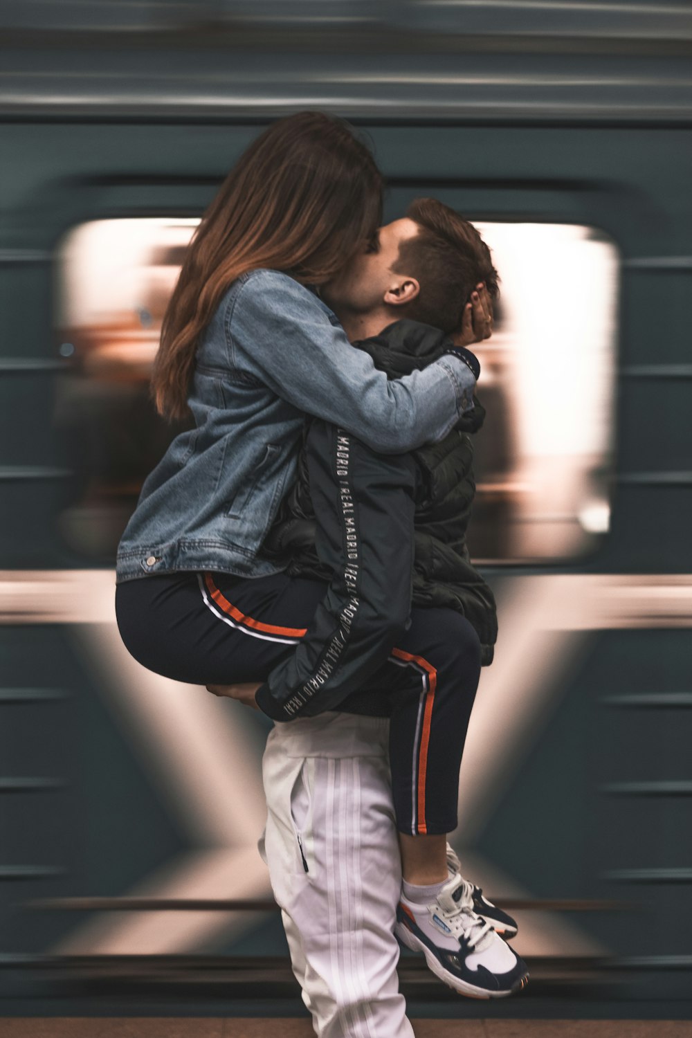 Femme en veste en jean bleue et pantalon blanc