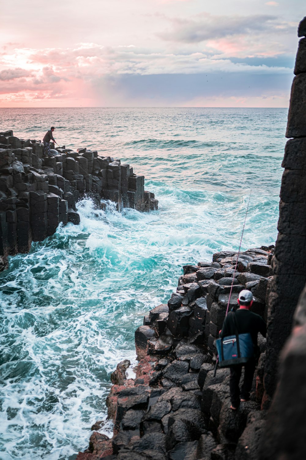 persone sulla costa rocciosa durante il giorno