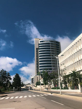 A modern municipal building in Domont with clear skies and people walking nearby.