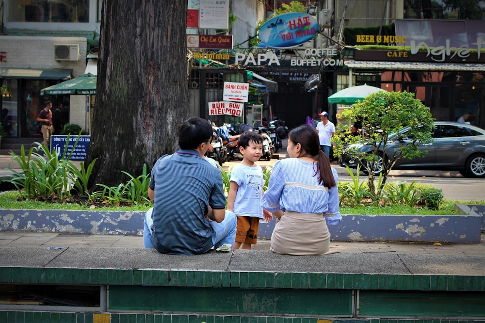 people sitting on bench near road during daytime