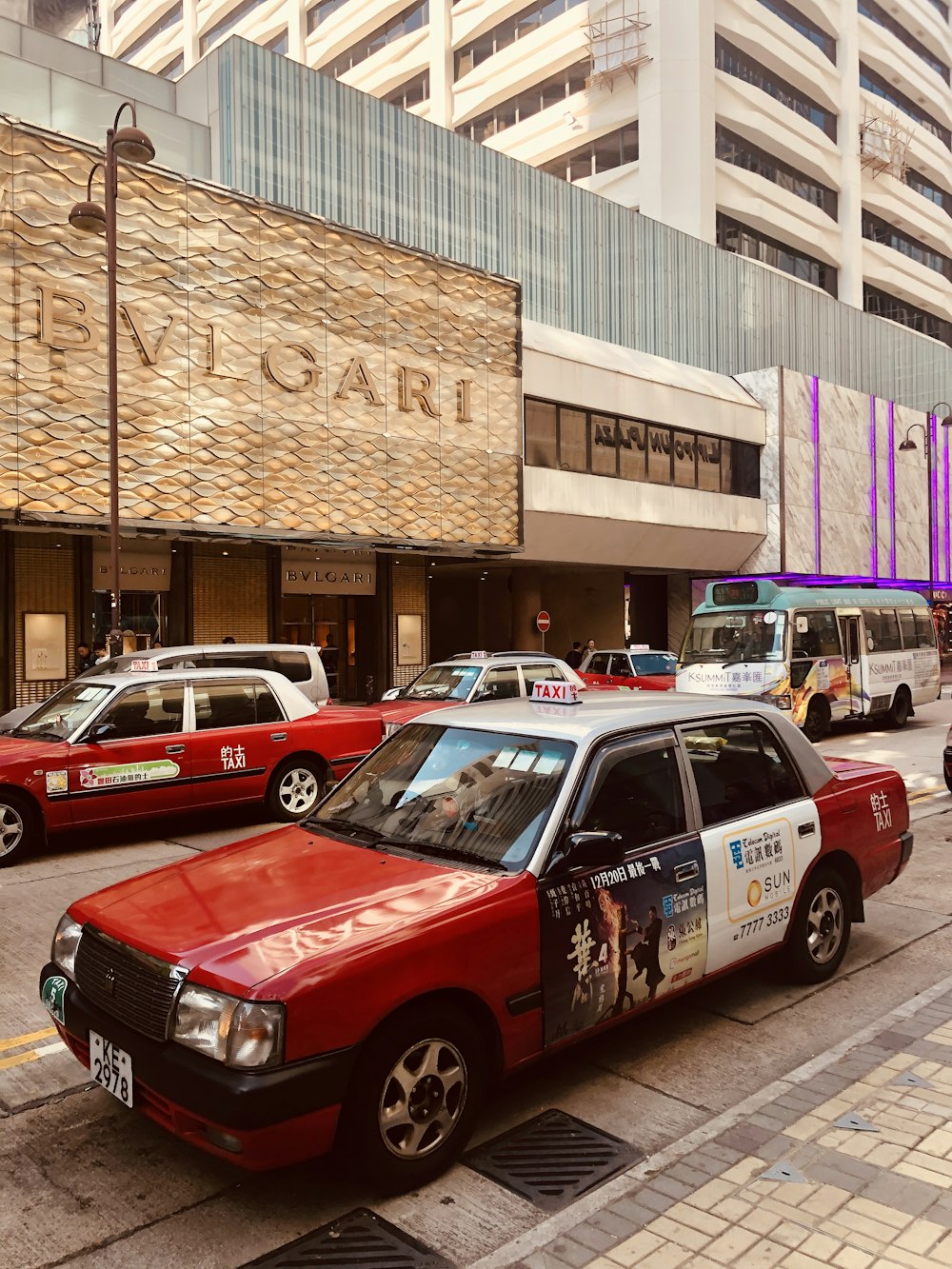 red and white cars on road near brown concrete building during daytime