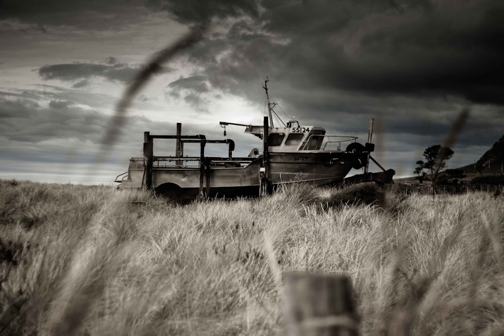 black and white utility trailer on brown grass field under cloudy sky during daytime