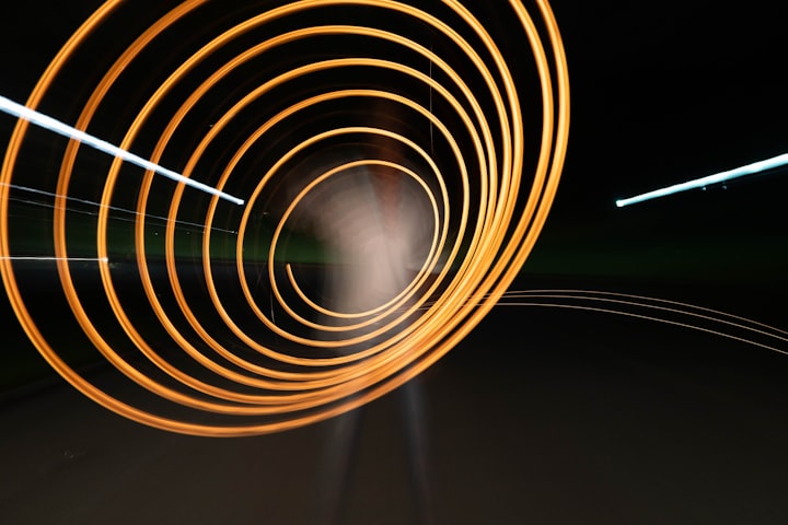 An abstract image of a glowing orange spiral in the shape of a sound wave, against a black background.