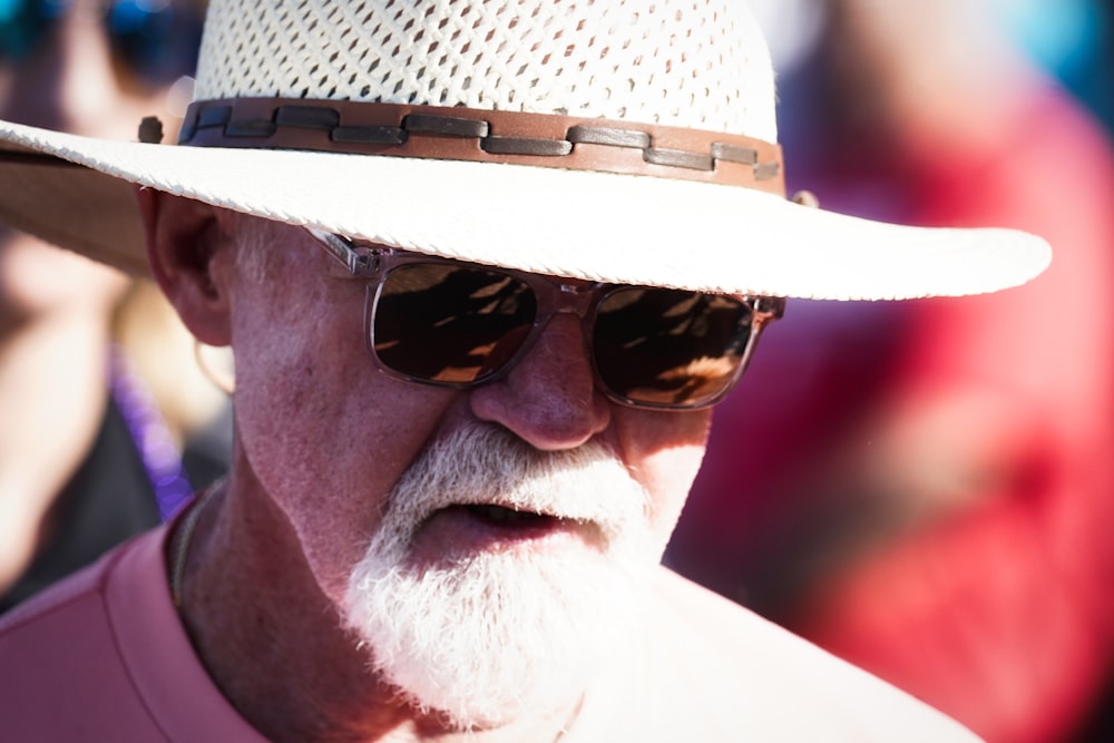 uomo che indossa occhiali da sole neri e cappello marrone