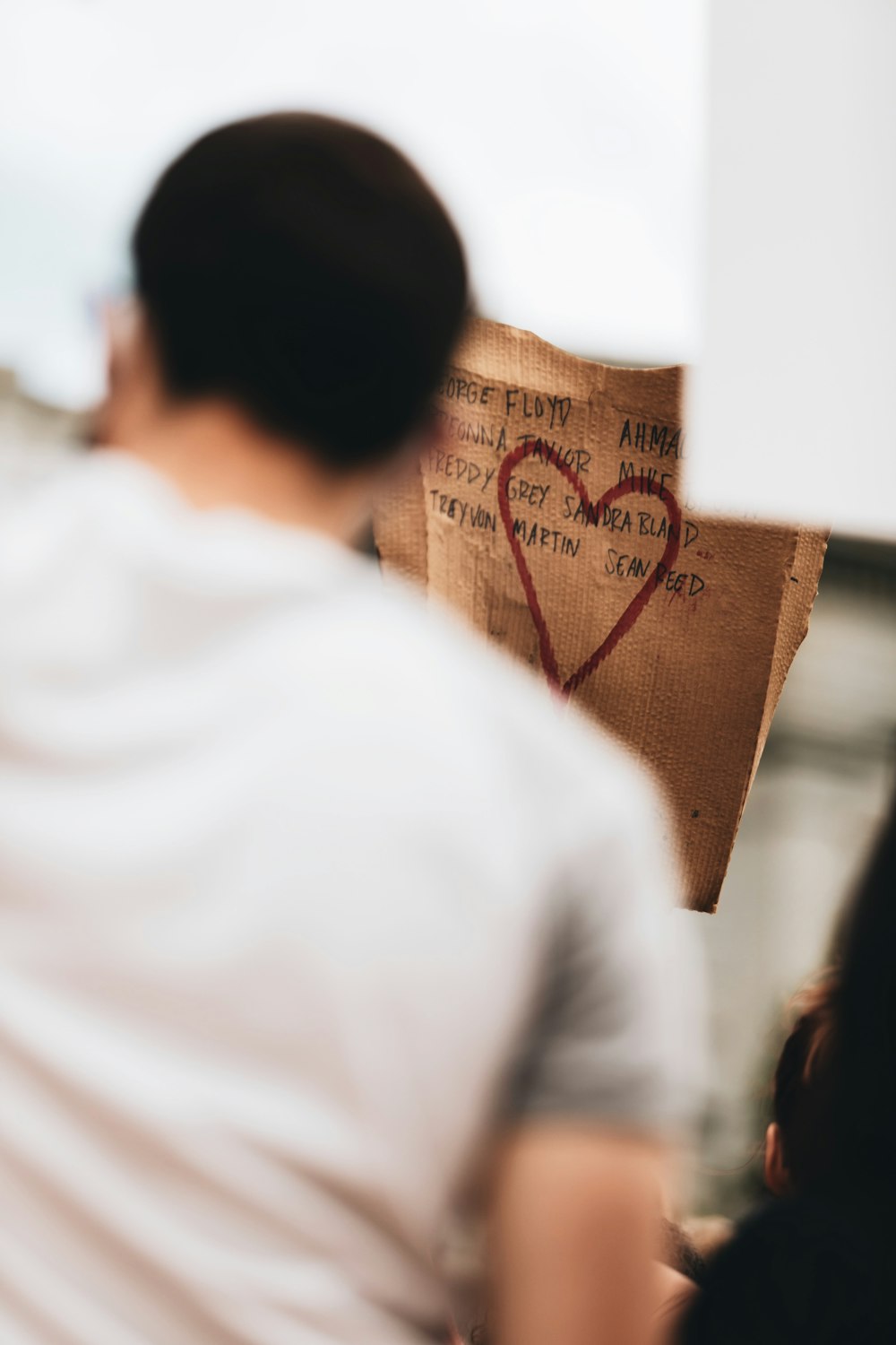 man in white shirt standing beside brown cardboard box