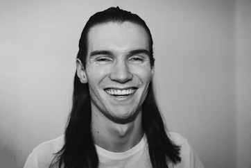 A candid portrait of Kianna Moya smiling confidently against a clean, minimal background.