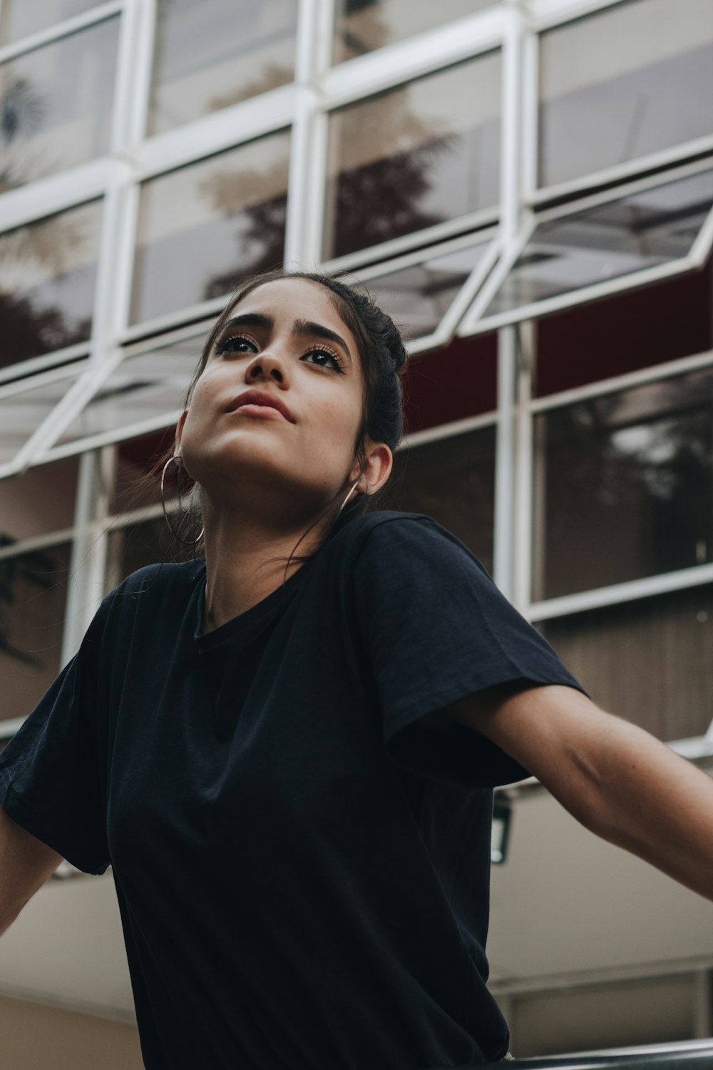 woman in black v neck t-shirt standing near white metal frame during daytime